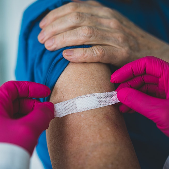 Provider applying Bandaid to upper arm